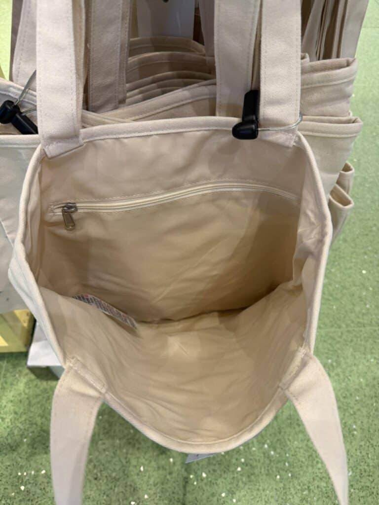 Backpack with beige fabric and black zipper details.