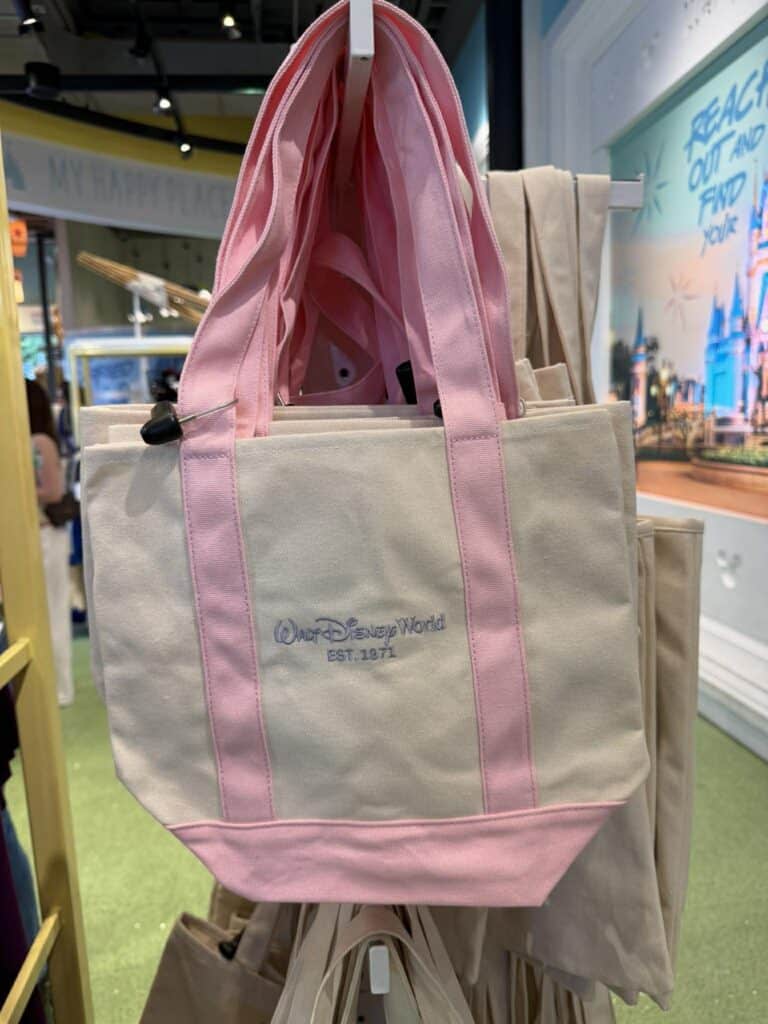 Disney World tote bag with pink handles and logo.