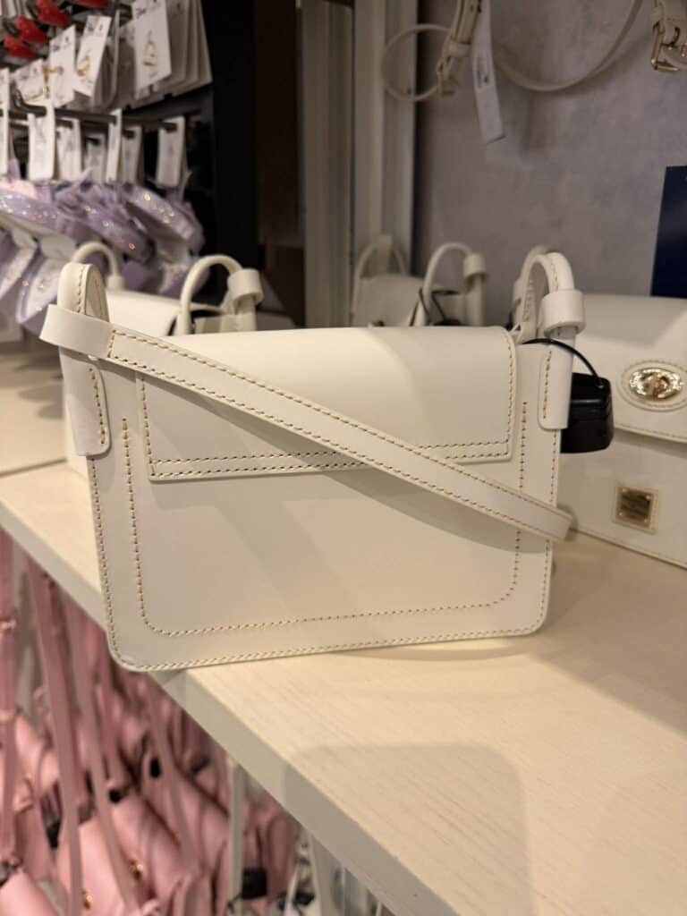 Neutral Mickey Dooney & Bourke crossbody bag on display at Disney store.