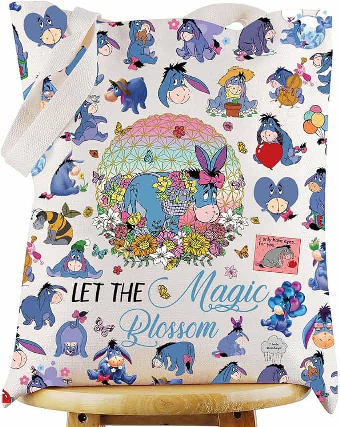Colorful Eeyore-themed tote bag featuring whimsical characters and floral accents, perfect for Disne.