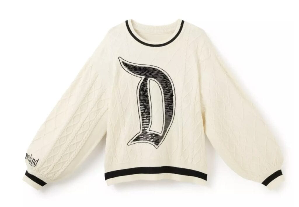 White cable knit sweater with Disney-inspired letter D design, black accents, and cozy style.