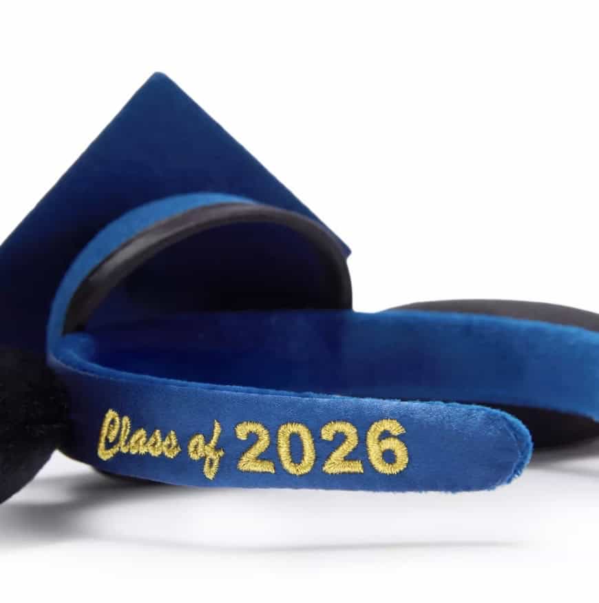 Graduation cap and sash with "Class of 2026" embroidered in gold, perfect for Disney-themed graduati.