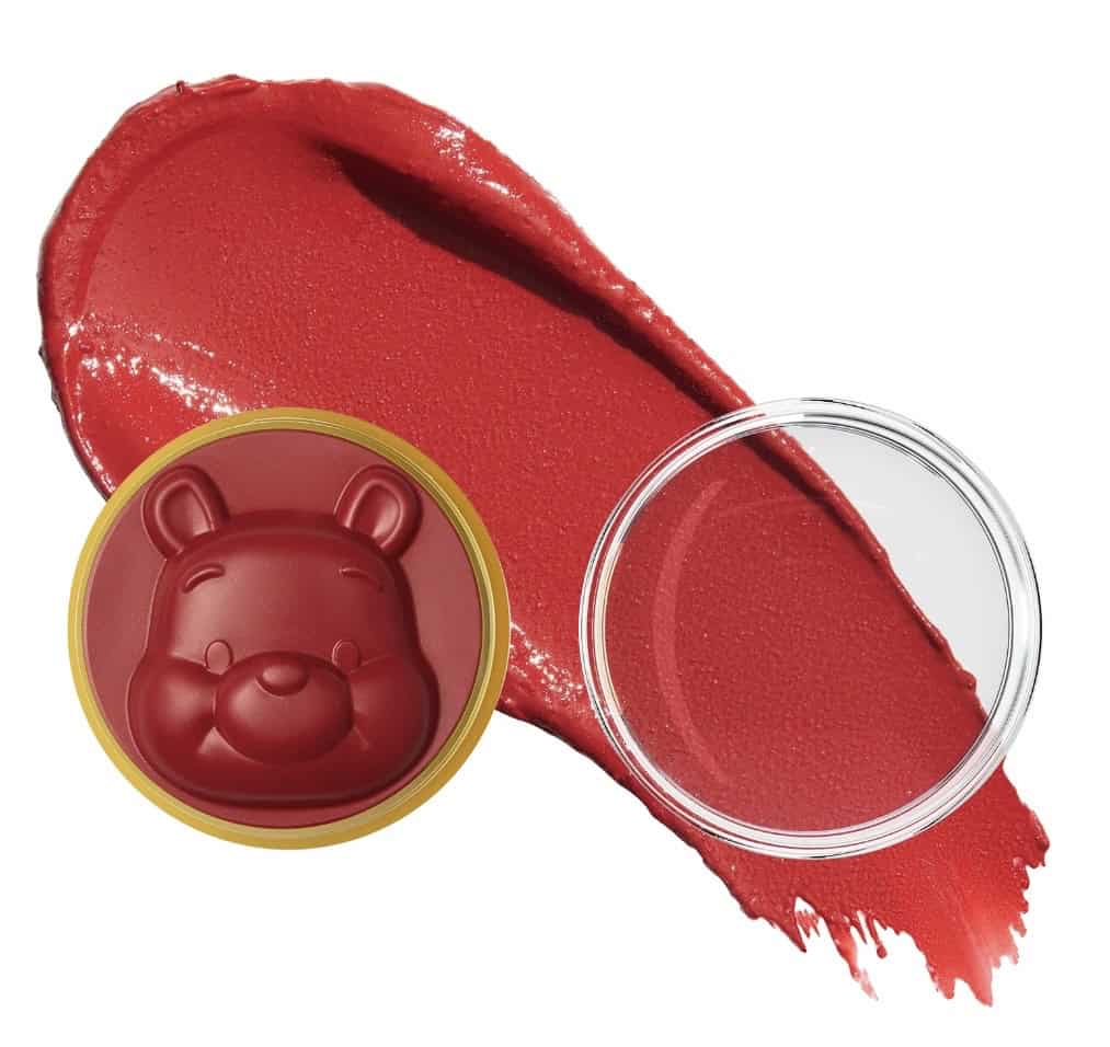 Red Disney bear-shaped lip balm with red lipstick smear background.