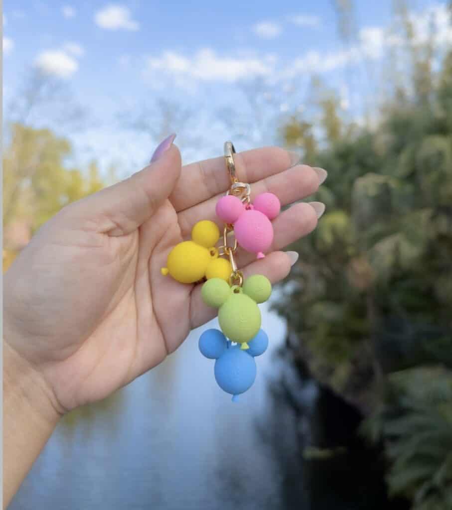 Bright multicolored Disney-themed bead keychain held outdoors.