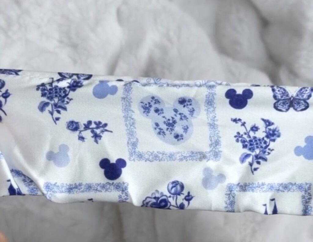 Blue floral fabric with Mickey Mouse and butterfly patterns for Disney-themed crafts.