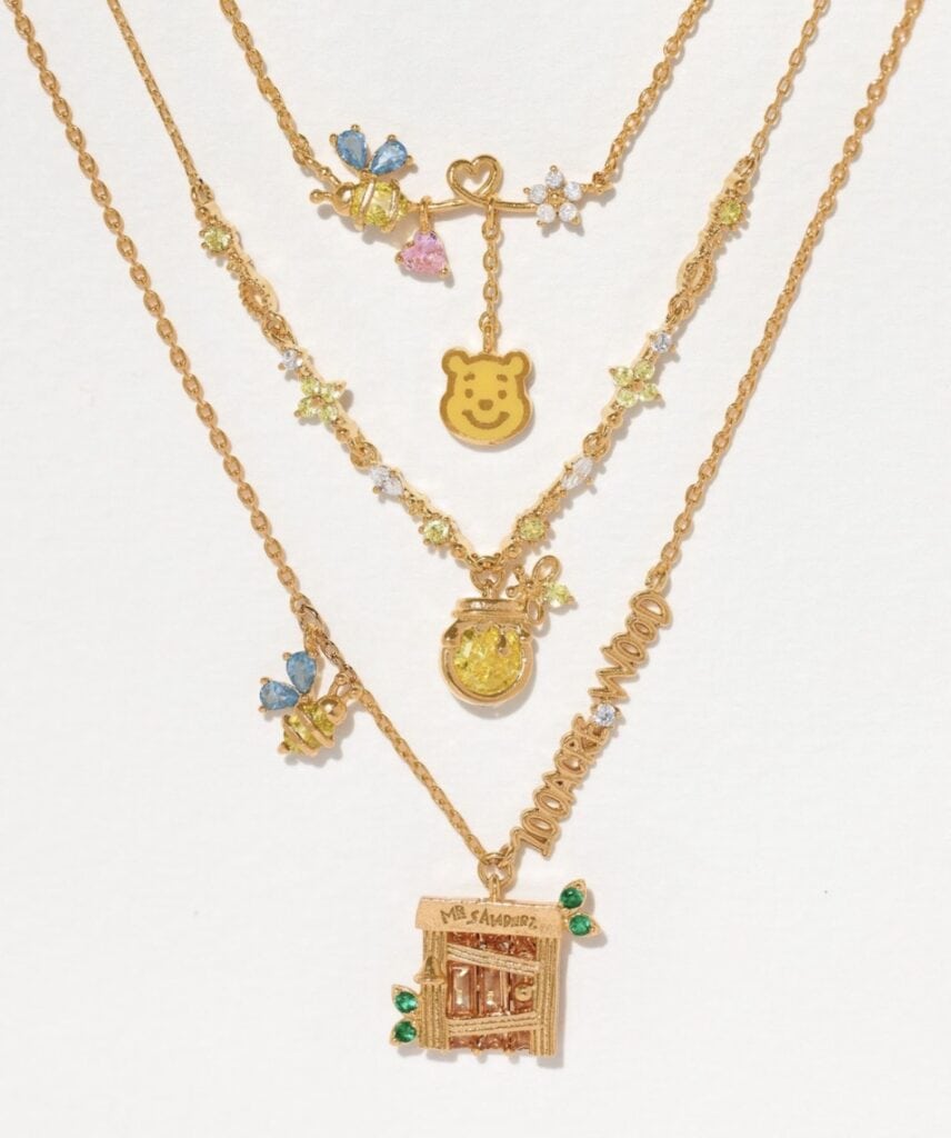 Elegant layered Disney-themed necklaces with colorful charms and gold finishes.