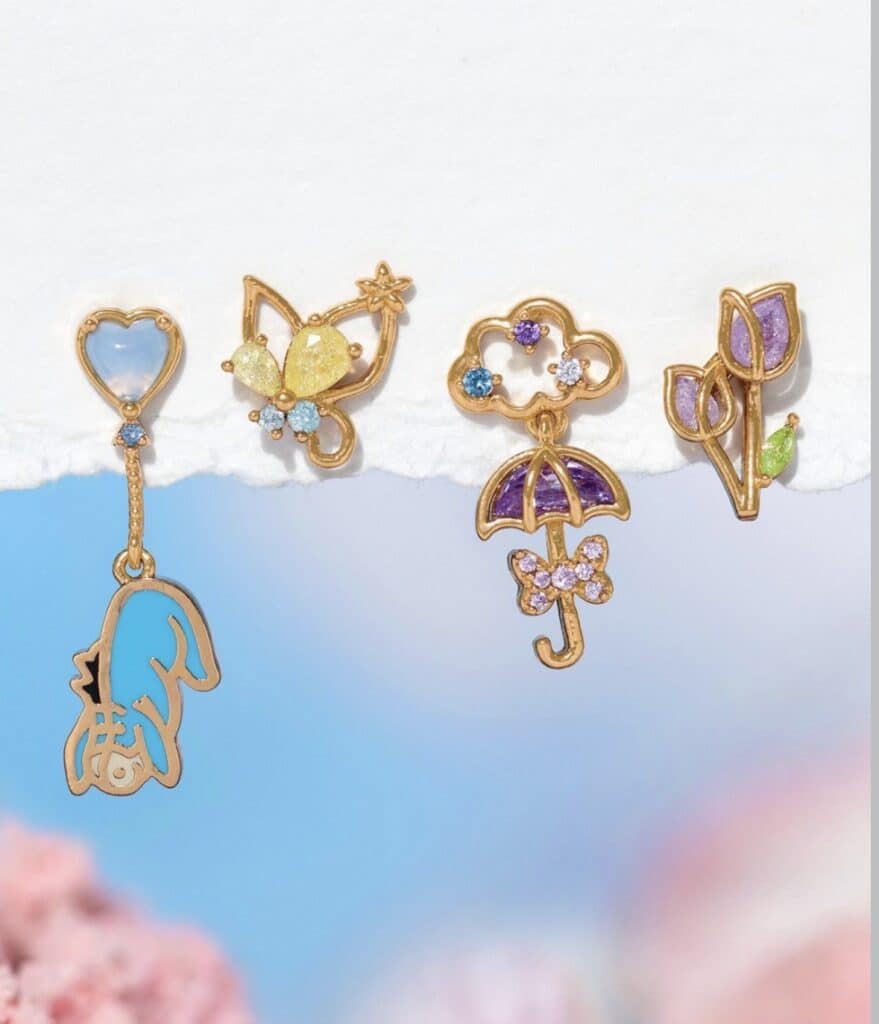 Colorful Disney-themed enamel pins with butterfly, umbrella, and floral designs.