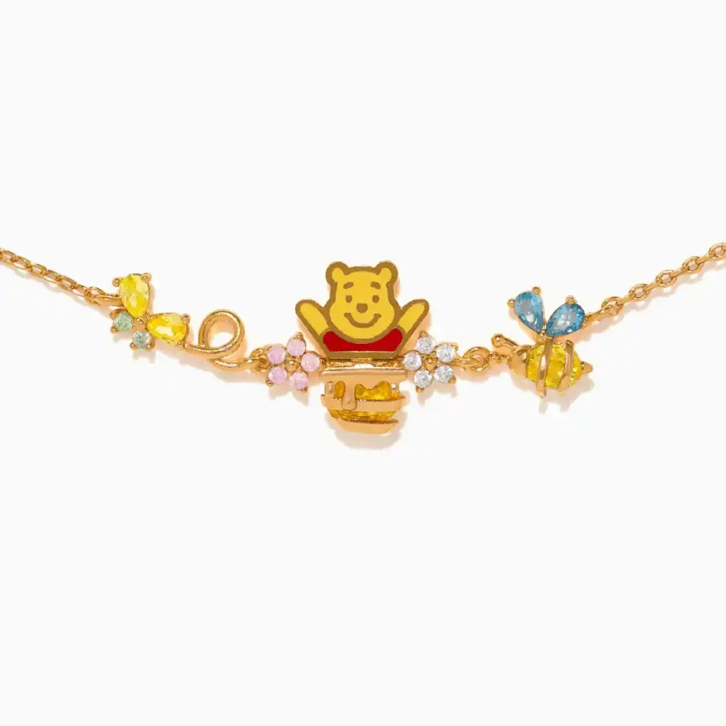 Gold Winnie the Pooh charm necklace with colorful bee and flower accents.