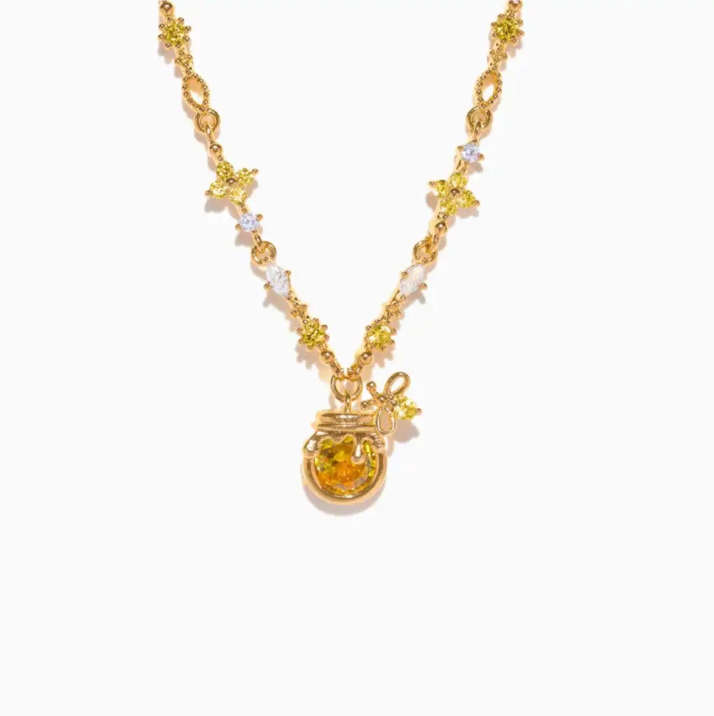 Gold necklace with Disney princess charm and colorful gemstone accents.