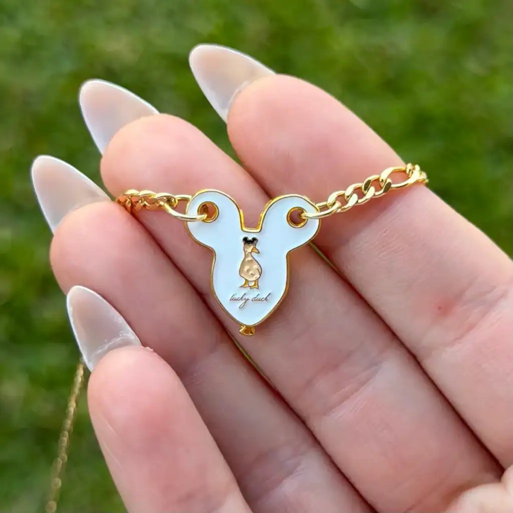 Gold chain necklace with mouse-shaped pendant featuring a small mouse illustration.