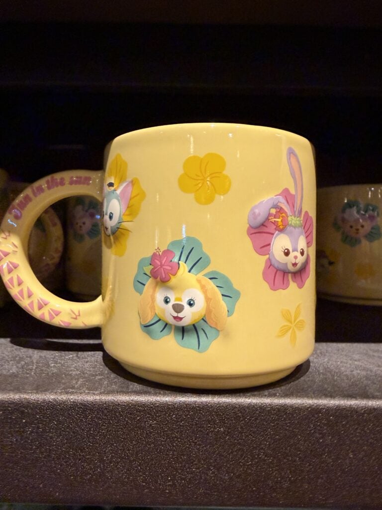 Yellow mug featuring adorable Disney puppy characters and colorful floral designs.