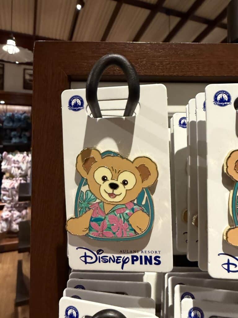 Disney pins featuring a cute bear character in a colorful Hawaiian shirt.