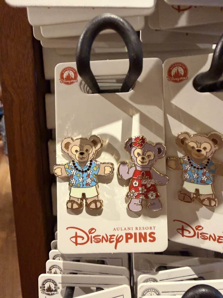 Disney bear pins with colorful outfits on display at Disney resort.