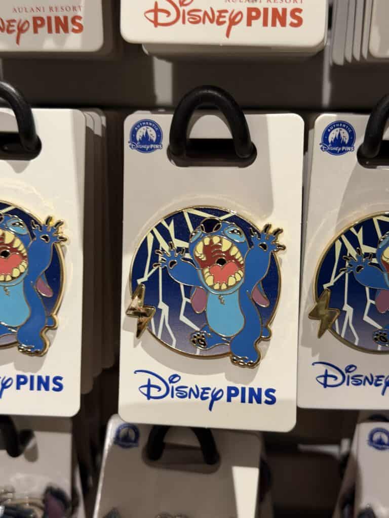 Colorful Stitch Disney pin with blue and gold accents, displayed on a white card.