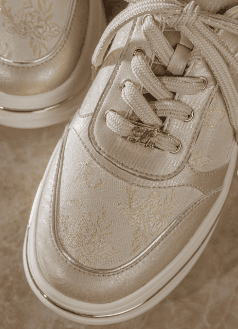 Disney fashion sneakers with gold detailing and floral motifs for stylish comfort.