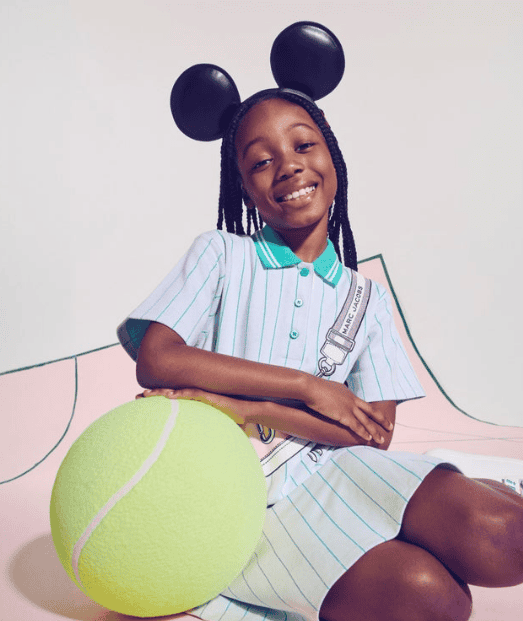 Young girl wearing Disney x Marc Jacobs tennis outfit with Mickey Mouse ears.