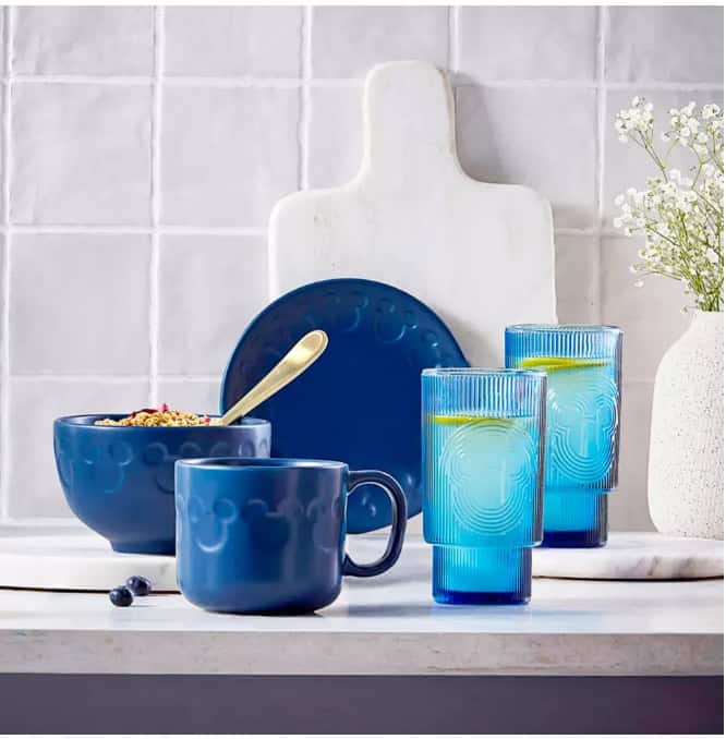 Vibrant blue dinnerware set with matching glasses and a white cutting board, perfect for Disney-them.