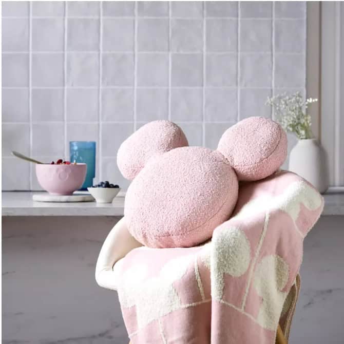Pink Mickey Mouse-shaped bath bombs on a cozy towel in a bathroom setting.
