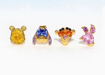 Colorful Disney-inspired jewelry featuring Pooh Bear, Eeyore, and friends with sparkling gemstones.