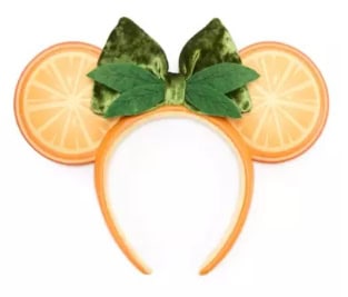 Cute Minnie Mouse headband with orange slices, lime leaves, and a green bow for fruit-inspired fashi.