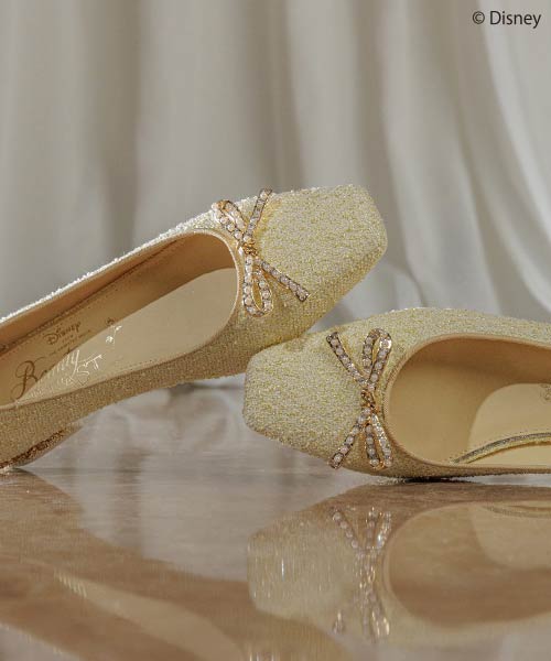 Disney-inspired gold glitter shoes with rhinestone bows for elegant events.