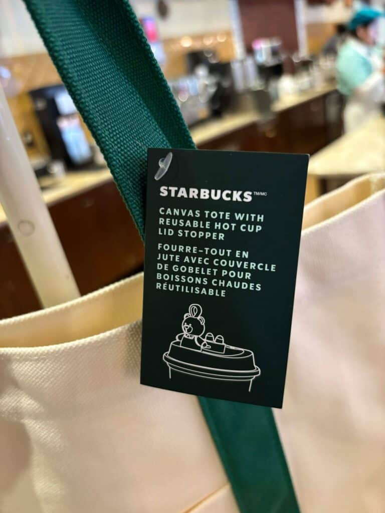 Disney canvas tote bag with reusable hot cup and lid, perfect for eco-friendly Disney fans.