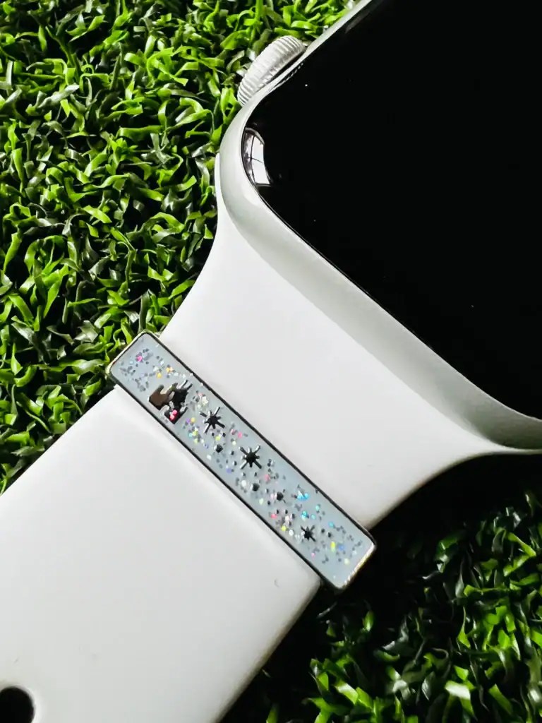 Disney-themed smartwatch with sparkly band on green grass.
