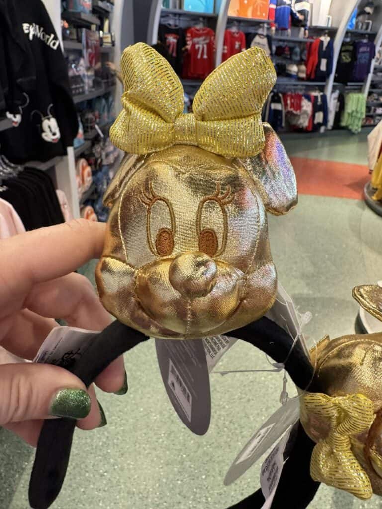 Gold Minnie Mouse headband with bow, perfect for Disney fans.