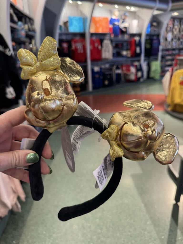 Gold Minnie Mouse headband with bow and ears, perfect Disney accessory for fans.