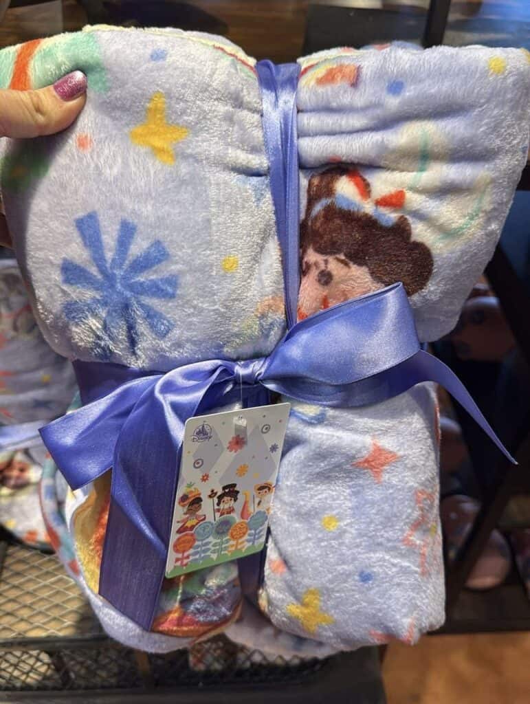 Disney character blanket with colorful prints and a satin ribbon tie.