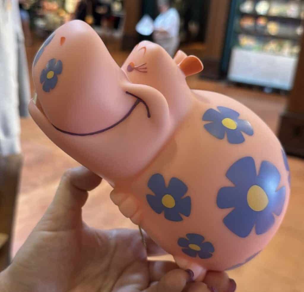 Whimsical Disney piggy bank with blue flowers and a happy face, perfect for saving money.
