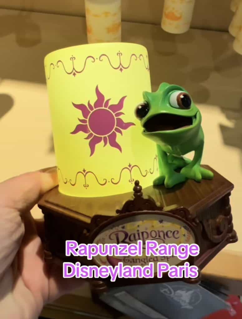Disney Rapunzel themed figurine with sun design on a decorative wooden stand.