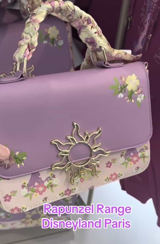 Elegant Disney Rapunzel-themed handbag with floral accents and sun motif clasp.