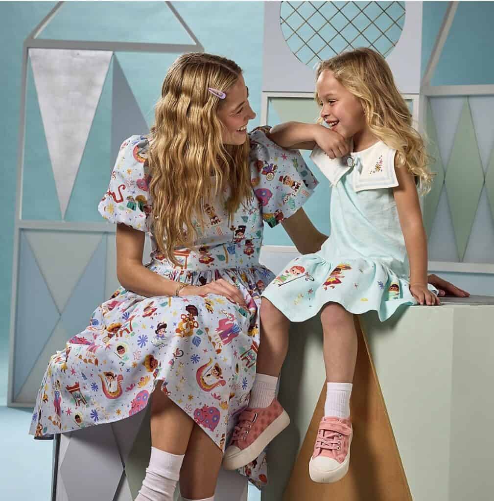 Two girls in colorful Disney-themed pajamas smiling and playing together.