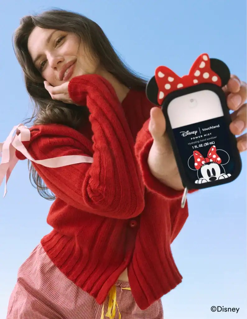 Woman holding a Disney Minnie Mouse touchscreen device with red bow design.