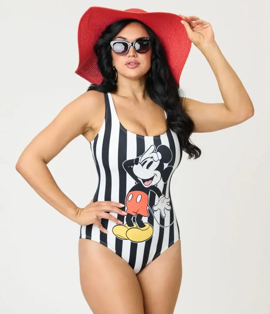 Woman in Mickey Mouse striped swimsuit with red sunhat and sunglasses.