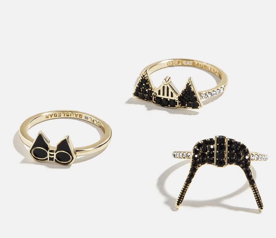 Elegant Disney-themed jewelry featuring black and gold rings with iconic motifs.