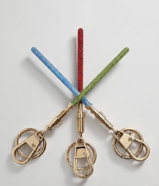 Bright Disney-themed keychains with glittery straps in red, blue, and green, featuring gold hardware.