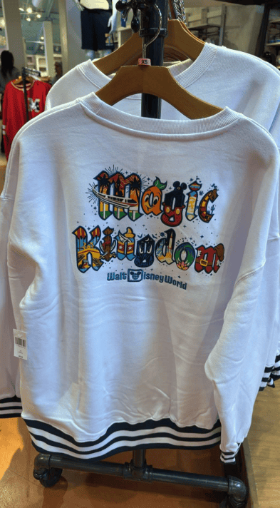 Cozy white Disney sweatshirt featuring Magic Kingdom design and colorful graphics.