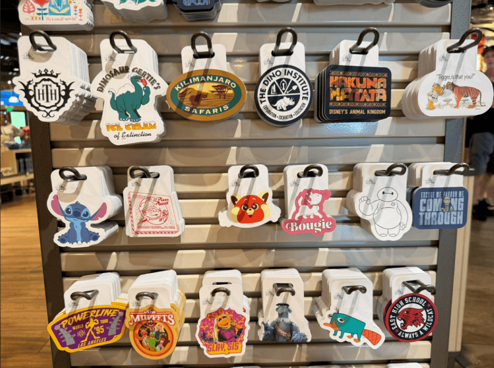Disney-themed luggage tags and accessories display on a retail shelf.