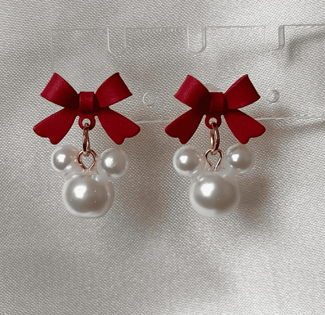 Cute Mini Mouse earrings with pearls and red bows for Disney fans.