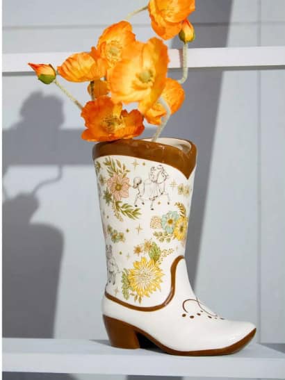 Disney flower vase shaped like a boot with orange poppies.
