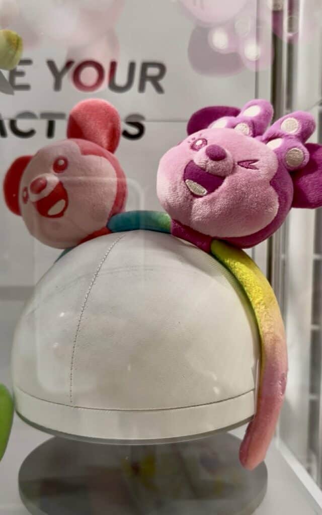 Adorable pink and purple plush toy featuring a cheerful Disney character with a rainbow tail.