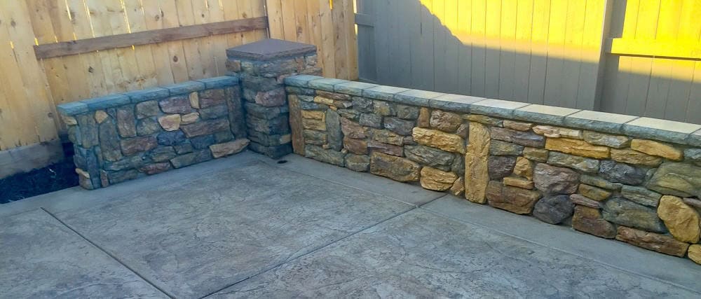 Concrete inline custom stone retaining wall with concrete patio in LINCOLN
