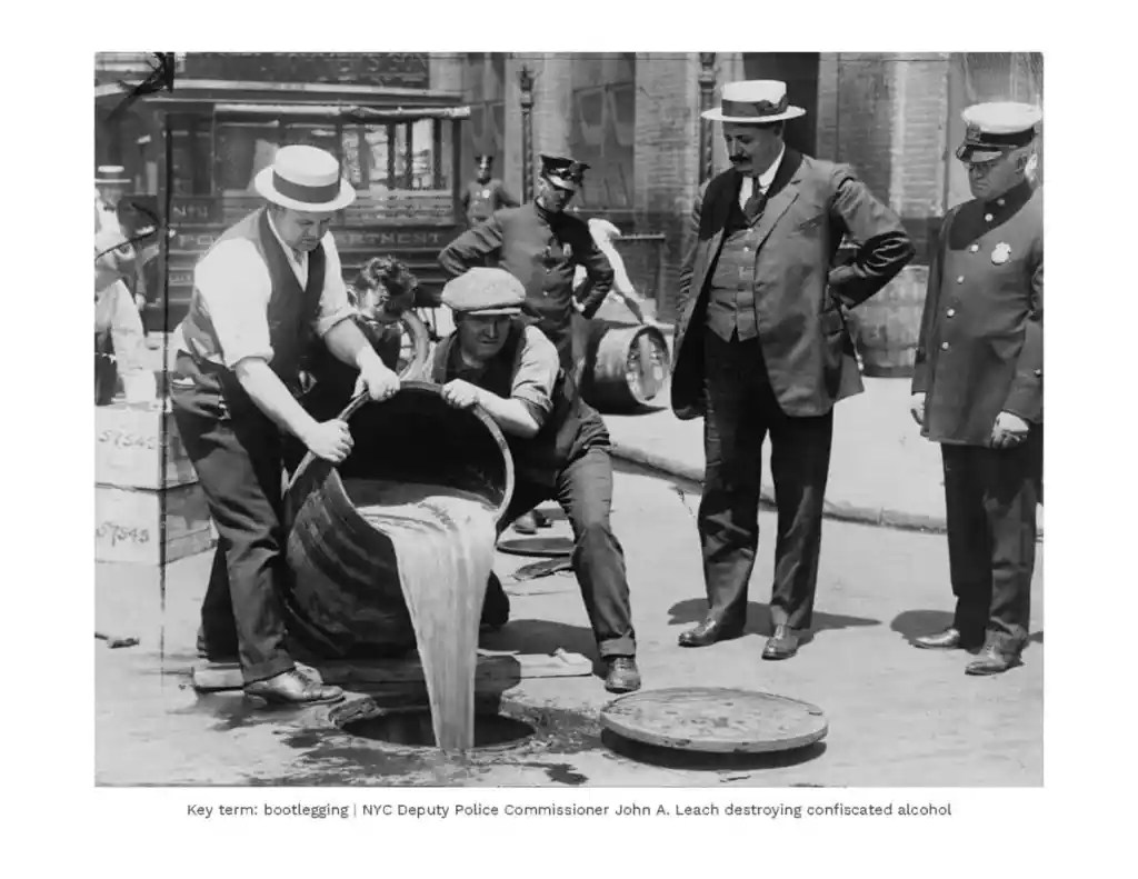 Bootlegging in NYC during Prohibition era, police officers destroying illegal alcohol.