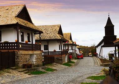 Traditional Hungarian village street with white houses and stone roofs, showcasing cultural heritage