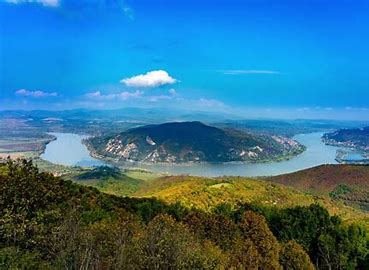 Scenic aerial view of Hungarian lake landscape with forested hills and blue water, representing prem