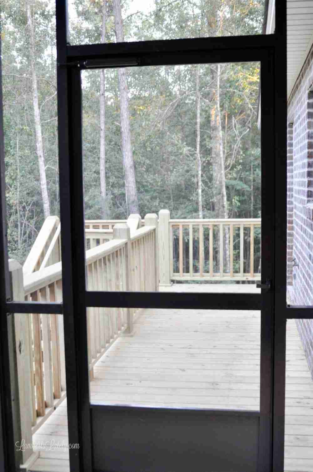 screen porch door looking out on a wood deck.