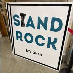 Sign for I39 Supply trailer dealership featuring "STAND ROCK STUDIOS" with bold text and a drill icon, promoting trailer sales and services at I39 Supply.