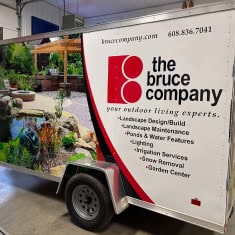 Image of The Bruce Company trailer showcasing outdoor living products, landscaping, and garden center services at I39 Supply Trailer Dealership.